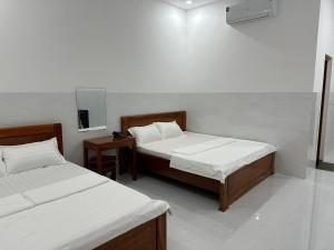 a room with two beds and a television in it at Hotel AN 52 in Phước Lộc Xã +4 photos