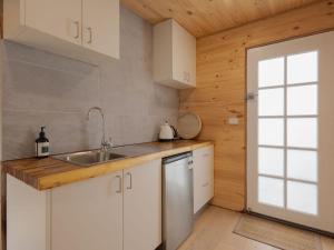 a kitchen with white cabinets and a sink and a window at Retro Retreat in Warrnambool