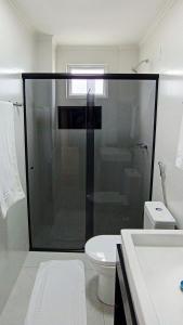 a bathroom with a glass shower and a toilet at Conforto perto do Mar, Aeroporto, Beto Carrero e Balneário in Navegantes +13 photos