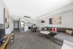 a living room with a couch and a table at One Bedroom Private Apartment at 88 Archer St Chatswood in Sydney