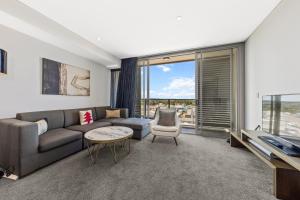 a living room with a couch and a tv at One Bedroom Private Apartment at 88 Archer St Chatswood in Sydney