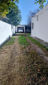 a dirt road with a white car in a garage at Casa hasta 5 personas in Villa Carlos Paz