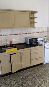 a kitchen with a microwave and a stove at Casa hasta 5 personas in Villa Carlos Paz