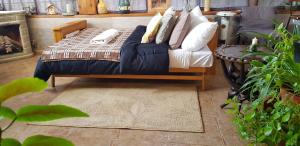 a bed with white pillows and a blue couch at Monoambiente El refugio in Río Grande