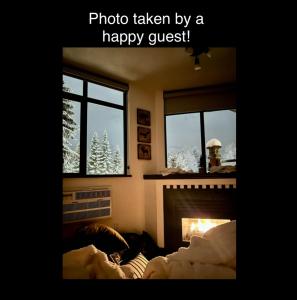 a living room with a fireplace and a christmas tree at Ideal Central Village Location! in Whistler +11 photos