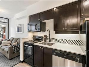 a kitchen with a sink and a stove top oven at Ideal Central Village Location! in Whistler