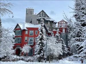 a large red building with snow on it at Ideal Central Village Location! in Whistler