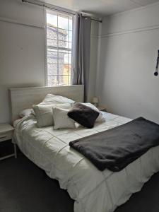 łóżko z dwiema poduszkami w sypialni w obiekcie Apartment In Nelson CBD Hospitality Zone w mieście Nelson