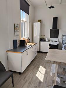 kuchnia z białymi szafkami i białą lodówką w obiekcie Apartment In Nelson CBD Hospitality Zone w mieście Nelson +12 zdjęć