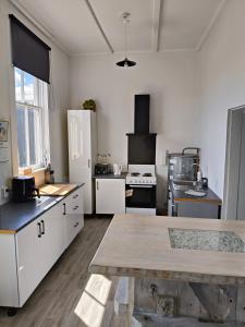 kuchnia z białymi szafkami i białą lodówką w obiekcie Apartment In Nelson CBD Hospitality Zone w mieście Nelson
