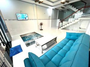 潘切Dolee House的客厅里有一张蓝色的沙发和一张桌子