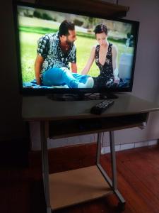 a tv screen with a man and a woman sitting on a table at Jakaranda B&B in Pretoria