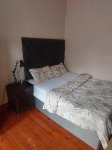 a bedroom with a bed and a lamp on a night stand at Jakaranda B&B in Pretoria
