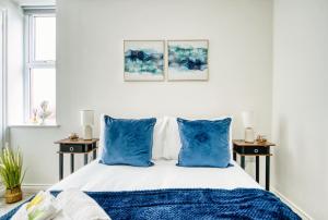 カーディフにあるStunning 2 Bed by the City Centre & Bute Parkの青い枕が付いたベッドのある寝室