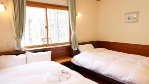 Postel nebo postele na pokoji v ubytování 軽井沢リゾートプチホテルみどり