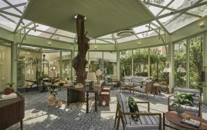 a conservatory with a tree in the middle of a room at President Maison Signature By M Village in Ho Chi Minh City