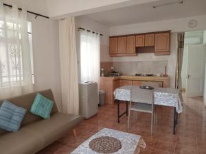 una sala de estar con un sofá y una mesa en Le Crecerelles 1-bedroom coastal apart, en Flic en Flac