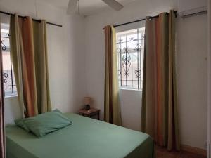 un dormitorio con una cama y una ventana en Le Crecerelles 1-bedroom coastal apart, en Flic en Flac