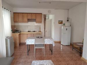 Una cocina con una mesa y un refrigerador blanco. en Le Crecerelles 1-bedroom coastal apart, en Flic en Flac