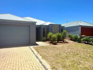 a house with a garage and plants in front of it at Hideaway on Peel in Busselton