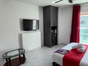 a bedroom with a bed and a table and a tv at Prime Suite at Ampang - Individual Private Rooms in Kuala Lumpur