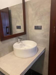 a white sink in a bathroom with a mirror at 7 Day Resort in Arugam Bay +80 photos