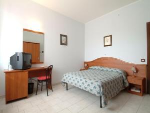 a bedroom with a bed and a desk and a tv at Il Leone D'Oro in Telgate