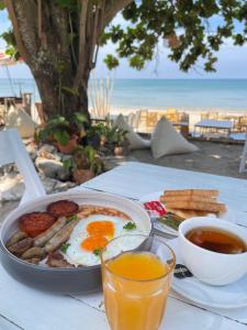 a table with a plate of breakfast food and drinks at De Hope Kohlanta in Ko Lanta Yai