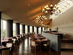a dining room with tables and chairs and chandeliers at Furano Resort Orika in Nakafurano