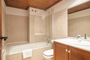 a bathroom with a tub and a toilet and a sink at Luderna - Apartamento Val de Ruda A5 Orla in Baqueira-Beret +8 photos