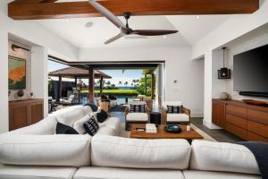 Una sala de estar con un sofá blanco y un televisor de pantalla plana. en Kukuiula Vacation Home #57, en Koloa