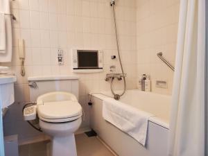 a bathroom with a toilet and a tub and a television at Furano Resort Orika in Nakafurano