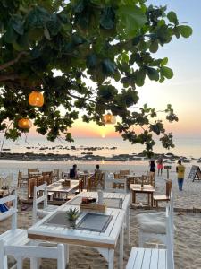 a beach with tables and chairs on the beach at De Hope Kohlanta in Ko Lanta Yai