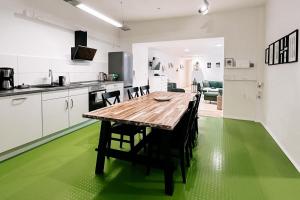 a kitchen with a wooden table and a green floor at Dohna, App 117 in Pirna