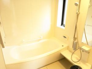 a white bath tub in a bathroom with a window at 有馬ヴィラ木の家 1日1組限定 貸し切りのリバーサイドヴィラ in Kobe +3 photos