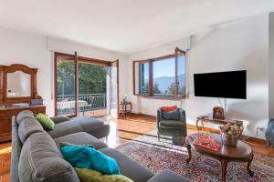 a living room with a couch and a flat screen tv at Casa Antonia - Happy Rentals in Porto Valtravaglia