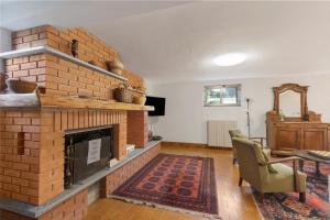 a living room with a brick fireplace and a table at Casa Antonia - Happy Rentals in Porto Valtravaglia +35 photos