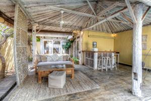 an outdoor living room with a couch and a table at Les Villas Ottalia Yoga & Diving, Gili Meno in Gili Meno
