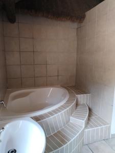 a bathroom with a tub and a tiled floor at lrish Mist Estate in Howick +54 photos