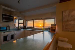 a kitchen with a counter and a large window at River City Views With Spa Pool, BBQ & Sky TV in Whanganui