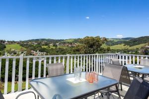 a blue table and chairs on a balcony at Kaleula Upper Beach House in Kiama