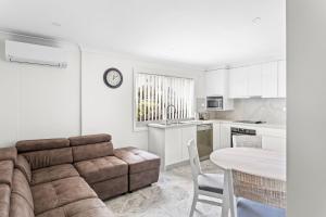 カイアマにあるKaleula Beach Apartmentのソファとテーブルのあるリビングルームとキッチン