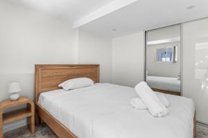 カイアマにあるKaleula Beach Apartmentの白いシーツと窓のあるベッドのある寝室 +11枚の写真
