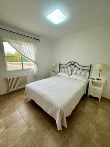 a bedroom with a large white bed and a window at Chalet Borriol Golf REF 028 in Borriol