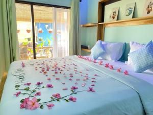 吉利阿尔Marta House gili air的一张床上放着一束鲜花