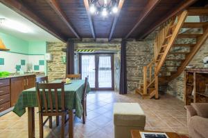 eine Küche und ein Esszimmer mit Tisch und Stühlen in der Unterkunft O forno do curro-Casiña Da Avelá in Boborás + 18 Fotos