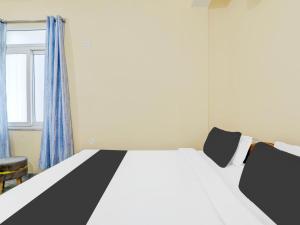 a bedroom with a large bed and a window at Hotel O Mellow Space in Patna +25 photos