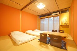a room with two beds and a table in it at 伏見稲荷の宿-Inari no Yado- in Kyoto