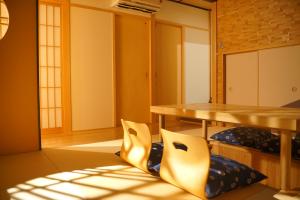 a room with a table and pillows on the floor at 伏見稲荷の宿-Inari no Yado- in Kyoto