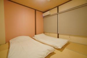 a small room with a white bed in it at 伏見稲荷の宿-Inari no Yado- in Kyoto +1 photo